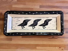 Load image into Gallery viewer, crow or raven carved pottery platter. crows are sgraffito carved into the center with footprints around the edge. stoneware, black on white clay.