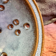 Load image into Gallery viewer, Detail image of Pint size berry colander. Wheel thrown pottery, red stoneware shown in Icy Blue glaze.