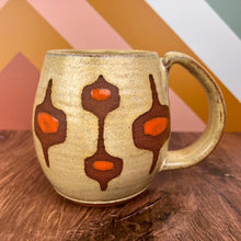 Load image into Gallery viewer, MidMod mug- freshly made vintage style. This mug features a soft dijon yellow glaze with orange accent spots showing through the midmod design resist in a deep rust red stoneware clay. full fingered handle with groovy thumb groove. Fern Street Pottery