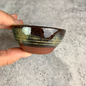 side view of a tiny bowl, showing the depth and the subtle lines formed when throwing the bowl on the potters wheel.