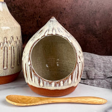 Load image into Gallery viewer, Salt Cellar, also known as a salt well or salt pig. shown here with matching Olive oil cruet. Wheel thrown and carved, with an &quot;onion dome shape&quot;. comes with a bamboo spoon and a starter sea salt packet.. Thrown in a red stoneware clay, with a handled top, and carved by hand. the white glaze accentuates the carved pattern where the red clay shows through. Fern Street Pottery