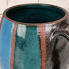 Load image into Gallery viewer, Detail shot of the Stripe mug with Teal, Turquoise, and Stardust (black glitter!)glaze hand painted on. red stoneware clay shows through between the stripes . Fern Street Pottery