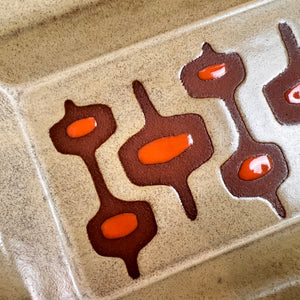 Closeup detail of the dijon and orange glaze on the deep red stoneware clay. beautiful MidMod resist pattern