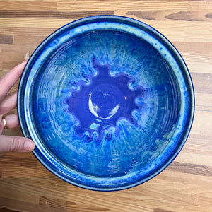 large "Blue World" serving bowl. wheelthrown, trimmed and glazed by Artist, Meredith Chernick. the bowl is glazed in cobalt blue with turquoise green glaze melting down into the blue from the rim of the bowl. No two are ever the same, each with unique drip patterns Approximtely 9" in Diameter