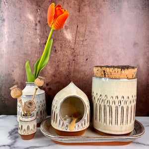 Canister (Medium size) for beautiful display and storage. this canister is wheel thrown from red stoneware clay, carved with a pattern and glazed in a speckled white glaze. the canister has a natural, rough cork lid. shown here with a mini bud vases, salt cellar and tray, sold separately.