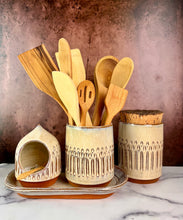 Load image into Gallery viewer, Canister (Medium size) for beautiful display and storage. this canister is made from red stoneware clay, carved with a pattern and glazed in a speckled white glaze. the canister has a natural, rough cork lid. shown here with salt cellar, utensil holder and utilitarian tray, each sold separately.