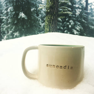 customized text mug sitting in the snow (mug reads: suncadia)