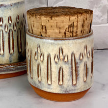 Load image into Gallery viewer, Canister for beautiful display and storage. this canister is made from red stoneware clay, carved with a pattern and glazed in a speckled white glaze. the canister has a natural, rough cork lid. approximately 3.5 inches wide and 3.5 inches tall