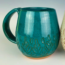 Load image into Gallery viewer, wheel thrown and hand carved mugs. the mug is thrownin red stoneware and glazed in a beautiful rich teal. the mugs have delicate patterns carved into them. shown here in the fern/tree carved pattern