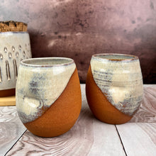 Load image into Gallery viewer, two pottery tumblers. Red stoneware clay, glazed in &quot;speckled white&quot; glaze which shows beautifully through the glaze. tumblers have finger divots and are dishwasher safe.