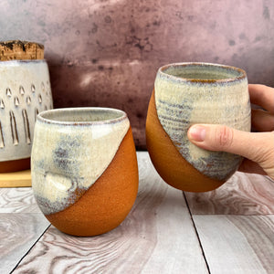 two pottery tumblers. Red stoneware clay, glazed in "speckled white" glaze which shows beautifully through the glaze. tumblers have finger divots and are dishwasher safe.