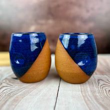 Load image into Gallery viewer, two pottery tumblers. Red stoneware clay, glazed in Blue glaze which shows softly through the glaze. tumblers have finger divots and are dishwasher safe.