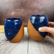 Load image into Gallery viewer, two pottery tumblers. Red stoneware clay, glazed in Blue glaze which subtly shows through the glaze. tumblers have finger divots and are dishwasher safe.