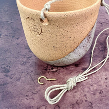 Load image into Gallery viewer, Hanging pottery planters shown with the hemp twine and included hanging hook.. hanging planter Thrown in speckled buff clay and angle dipped glazed in speckled white. planters are strung with hemp twine and have NO drainage hole. Wheel thrown and handcrafted at Fern Street Pottery