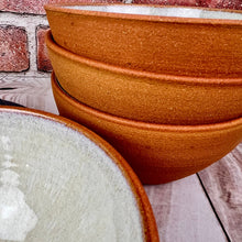 Load image into Gallery viewer, Detail image of stoneware bowl set. set of four stacking bowls, perfect size for soup, cereal, salad, or ice cream. These bowls are perfect for cereal, serving or soup. The Interior was Glazed with the Glaze Splash Glaze Fountain, this version was left glazefree on the exterior and feature the red-brown exposed stoneware clay in its natural state..