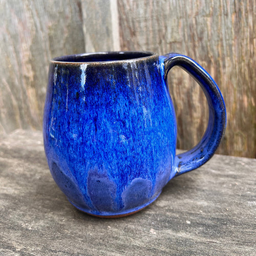 Deep Blue mug in a classic northwest shape which is designed to keep your coffe warm longer on our chill NW days. Wheelthrown, and trimmed, with a pulled handle. The deep blue glaze is made up of a few different layers of Blue glazes that play beautifully together. This glaze differs from the Blue World color in that it lacks the turquoise underlayers. so much blue!