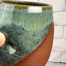 Load image into Gallery viewer, detail shot of tumbler glazed in Moss Green. angle dipped so the red stoneware clay shows through. 