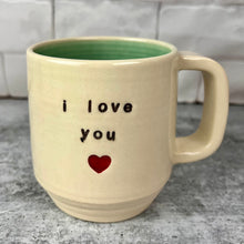 Load image into Gallery viewer, &quot;i love you&quot; stamped into a mug, with a heart stamped under the text. White clay, turquoise glaze on the inside. this mug was wheel thrown then hand stamped and colored at fern street pottery.