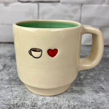 Load image into Gallery viewer, Image of a coffee mug and a red heart, stamped into the mug. artist thrown in White clay, turquoise glaze on the inside. this mug was wheel thrown and hand stamped and colored at fern street pottery.