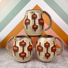 Load image into Gallery viewer, Three ceramic mugs with MidMid patterns on a geometric background. Handcrafted, wheel thrown mug by Meredith Chernick at Fern Street Pottery. Hand painted resist and glaze pattern in light dijon yellow, deep red stoneware clay, and bright orange dots. 