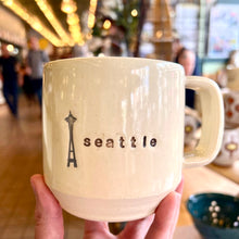 Load image into Gallery viewer,  Wheel thrown pottery mug with &quot;seattle&quot; and an image of the space needle inset on the outside. white outside, turquoise green glaze interior
