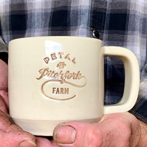 a customized logo on a mug. logo is stamped in and colored with brown on a white mug.