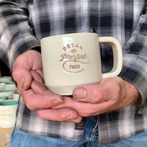 a customized logo stamped into a mug, and inset with brown on white clay.