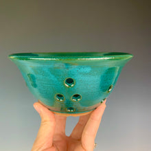 Load image into Gallery viewer, Berry colander in teal glaze on red clay. shown being held by the artist for scale. holds a pint to a pint and a half