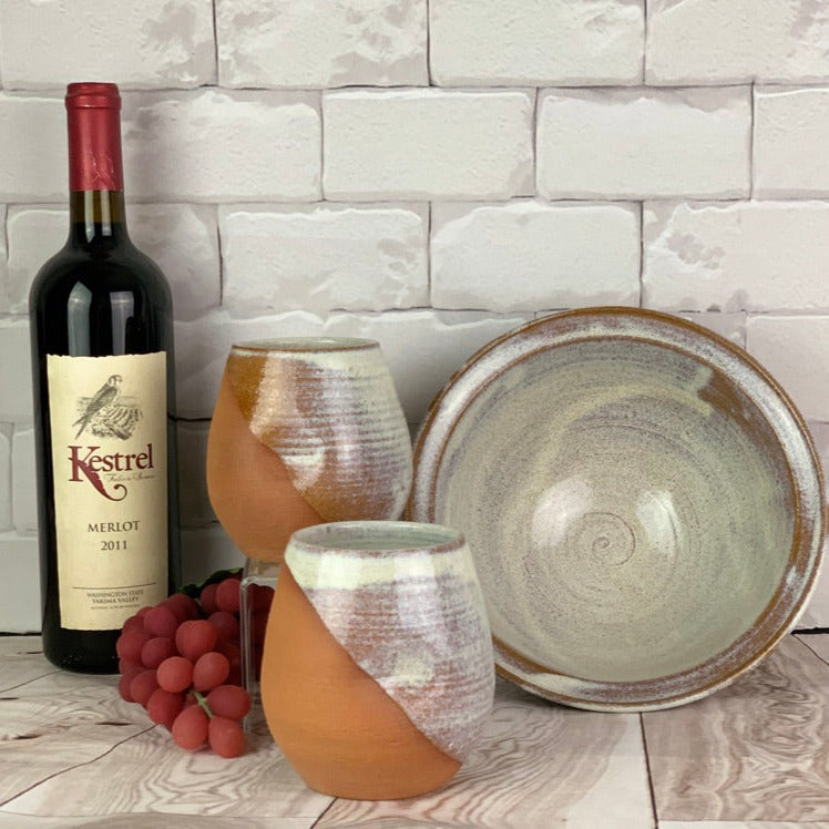 Artisan crafted serving bowls in a rustic Speckled White glaze shown with wine tumblers. bowls are  8