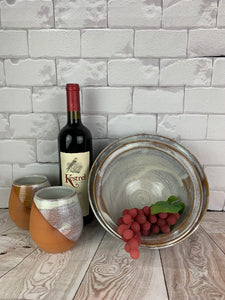 Artisan crafted serving bowls in a rustic Speckled White glaze shown with wine tumblers. bowls are  8" and 9" in diameter