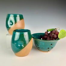 Load image into Gallery viewer, Stemless wine glasses. wheel thrown pottery with finger divots for grip. Teal green glaze over red stoneware clay, glazed at an angle to reveal the clay. shown with berry colander and grapes in teal