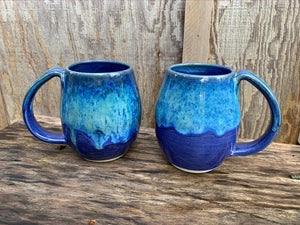 two blue world mugs. no two are alike, the glaze melts and plays differently on each mug