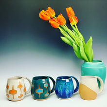 Load image into Gallery viewer, Other mugs available from Fern Street Pottery in the northwest shape. shown here in angle dipped glaze pattern, and MidMod patterns. Also shown with vase in teal 