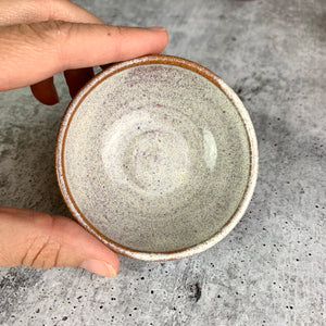 tiny sauce bowl, wheel thrown at Fern Street Pottery, shown in speckled white on. red stoneware clay