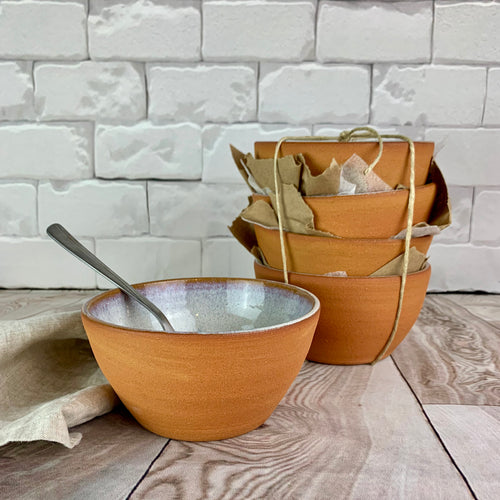 Showing one bowl interior glazed, exterior unglazed stoneware.(comes in a set of four.)   These bowls are glazed with a speckled, rustic white glaze inside and feature the red-brown exposed stoneware clay on the exterior.