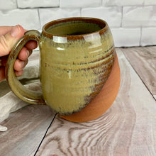 Load image into Gallery viewer, Fern Street Pottery. Angle dipped mug. the artist holding the full-grip handle, angle dipped mug in caramel