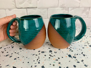 two angle dipped mugs glazed in stoneware. the mugs have a large, hand pulled handle for a full grip. Fern Street Pottery. Angle dipped mug.