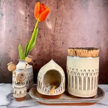 Load image into Gallery viewer, Canister (Medium size) for beautiful display and storage. this canister is wheel thrown from red stoneware clay, carved with a pattern and glazed in a speckled white glaze. the canister has a natural, rough cork lid. shown here with a mini bud vases, salt cellar and tray, sold separately.
