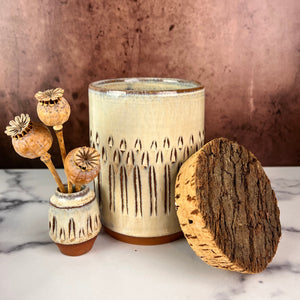 Canister (Medium size) for beautiful display and storage. this canister is wheel thrown from red stoneware clay, carved with a pattern and glazed in a speckled white glaze. the canister has a natural, rough cork lid. shown here with a mini bud vase, sold separately.
