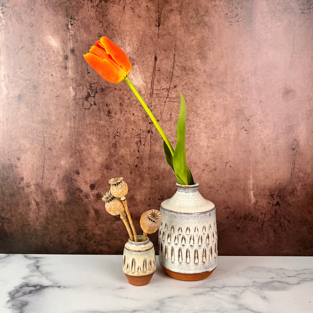 Bud vase thrown in red stoneware clay, carved and glazed in speckled white clay. Shown here along side a Mini Bud vase