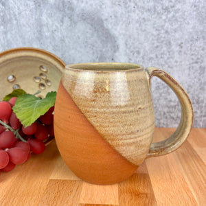 Wheel thrown and hand crafted in red-brown stonware clay, this angle dipped mug is featured in a dijon glaze which shows the beautiful stoneware color beneath. beautiful color and textures. holds 14-16 oz