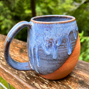 Wheel thrown and hand crafted in red-brown stonware clay, this angle dipped mug is featured in a drippy light blue glaze which lets the red clay show through. beautiful light blue mottled color and textures. holds 14-16 oz