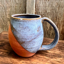 Load image into Gallery viewer, Fern Street Pottery. Angle dipped mug. Wheel thrown and hand crafted in red-brown stonware clay, this angle dipped mug is featured soft light blue glaze which lets the red clay show through. beautiful light blue mottled color and textures. holds 14-16 oz