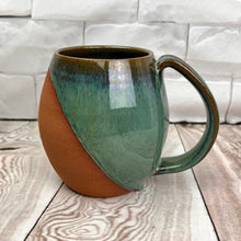 Load image into Gallery viewer, Wheel thrown and hand crafted in red-brown stonware clay, this angle dipped mug is featured in a drippy moss green glaze. beautiful color and textures. holds 14-16 oz