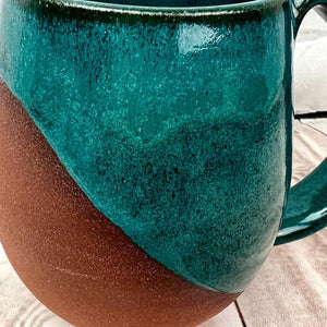 close up image of the beautiful Teal Glaze on the deep red stonewareFern Street Pottery. Angle dipped mug.