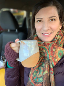 Fern Street Pottery's Meredith, holding her northwest contemporary style, angle dipped mug. White glaze, angle dipped, on red clay. Fern Street Pottery. Angle dipped mug.
