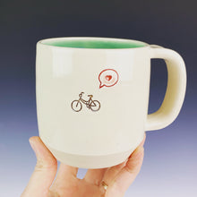 Load image into Gallery viewer, Bike love mug for the bicycle lover. white cylindrical mug with a pug stamped in in brown, and a heart in a speech bubble in red. Turquoise green interior on this mug.