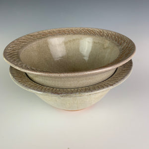 stacked red pottery stoneware bowls in white speckled glaze with  carved rim serving bowl. the pots are thrown on the potters wheel, bowls are approximately 7" in diameter 