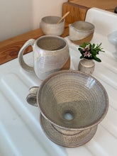 Load image into Gallery viewer, showing the inside of a pottery coffee pour over. notice the wheel thrown pattern inside the cone shape. also shown in the background: matching mug, cream and sugar set and carved bud vase. Fern Street Pottery