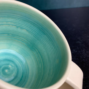 a custom mug shown with standard turquoise glaze inside